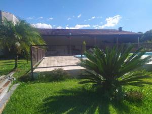 un patio con una valla y una palmera en Espaço Recanto do Guerreiro, en Pindamonhangaba