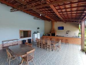 Una habitación con una mesa y sillas y una cocina. en Espaço Recanto do Guerreiro, en Pindamonhangaba