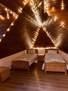 two beds in a room with lights on the ceiling at Anano Apartment on Botanikuri in Tbilisi City