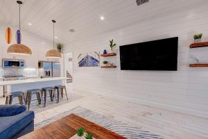 a living room with a flat screen tv on a wall at Double Dunes! Heated Pool with Ocean Views! in Port Aransas