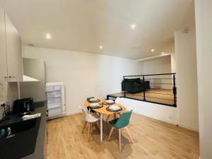 a kitchen with a table and chairs in a room at City Loft Valence hyper-centre in Valence