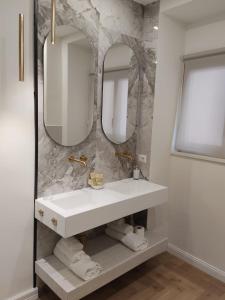 a bathroom with a white sink and two mirrors at B&B San Pancrazio hotelHouse in Catania +30 photos