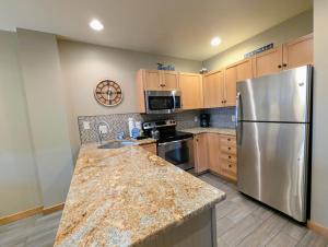 a kitchen with a stainless steel refrigerator and wooden cabinets at Dakota Lodge 8503 by SummitCove Lodging in Colorado in Keystone