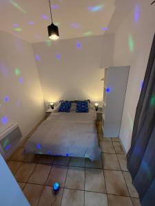 a bedroom with a bed and blue lights on the ceiling at Flandre 02 in Roubaix