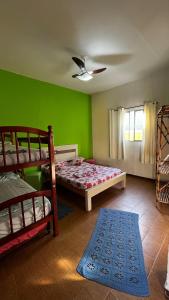 a bedroom with two bunk beds and a green wall at Hostel Beira Mar in Ilha Comprida