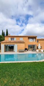 una casa con piscina delante de una casa en Villa Alta Rocca, en Le Tholonet
