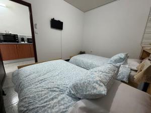 una camera da letto con due letti e una televisione a parete di Casa independente, confortável e muito agradável a Pardilhó