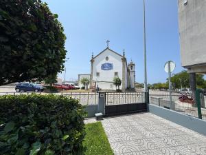 una chiesa con una croce sul lato di un edificio di Casa independente, confortável e muito agradável a Pardilhó