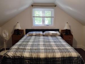 a bedroom with a bed with two lamps and a window at Serene Getaway Nordic Spa , Sauna, Nature & Pool in Rawdon +84 photos