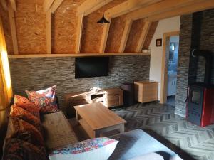 a living room with a couch and a tv on a brick wall at D&N place - forest house Zabljak in Žabljak