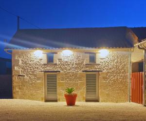 a stone house with a plant in front of it at La chambre aux hommes in Lusignan +3 photos