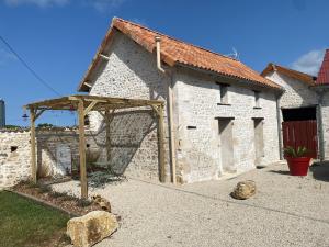 a building with a wooden archway in front of it at La chambre aux hommes in Lusignan