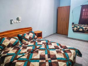 a bedroom with a bed with a colorful quilt at Fleur d'hibiscus in Cotonou