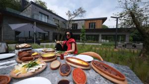 a woman sitting at a table with food on it at Melekona House in Kartepe