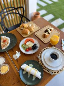 a wooden table with plates of food on it at Yahweh Hotel in São Miguel do Gostoso