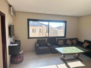 a living room with a couch and a table and a window at Appart For Rent Kech in Marrakech