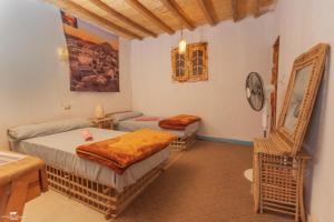 a room with two beds and a table and a clock at Gagal House in Siwa +37 photos