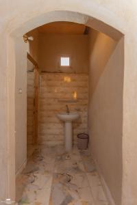 a bathroom with a sink in a room with a wall at Gagal House in Siwa