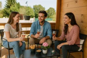 a group of three people sitting around a table with wine glasses at Charmant chalet au cœur de la Sologne in Villefranche-Sur-Cher