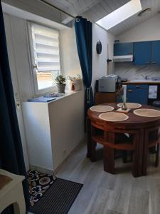 una piccola cucina con un tavolo in una stanza di Studio Sulniac Golfe du morbihan avec piscine au sein du domaine a Sulniac