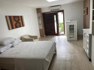 a bedroom with a bed and a room with a door at Quarto in São Francisco do Sul