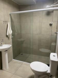 a bathroom with a shower with a toilet and a sink at Quarto in São Francisco do Sul