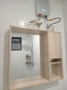Armario de madera con baño con ducha en Lester's Luxe Studio Apartment, en Ruaka