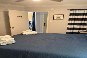 a bedroom with a blue bed with towels on it at Ocean & Pool Views Top Floor - Shoreline Stays 03 in Galveston +44 photos