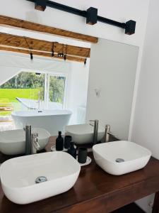 a bathroom with two sinks on a wooden counter at THE W Villa in Topliţa