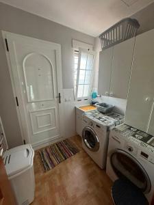 Una cocina con lavadora y secadora en una habitación. en Villa Loli, Quiet villa with pool, next to beach and city, en Grao de Castellón