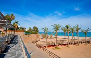 una playa con bancos, palmeras y el océano en Villa Loli, Quiet villa with pool, next to beach and city, en Grao de Castellón