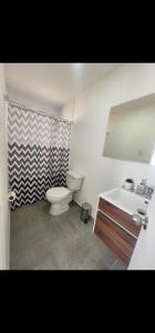een badkamer met een toilet, een wastafel en een spiegel bij Casa nueva amoblada in Ovalle +7 foto's