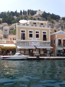 a boat is docked in front of a building on the water at Captain's Suites in Symi