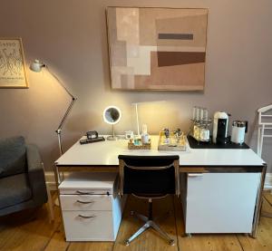 an office with a desk with a chair and a lamp at A different room in Frankfurt/Main