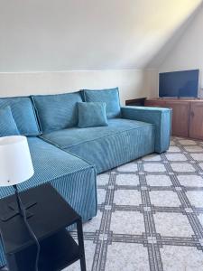 a living room with a blue couch and a table at Nocuj u Rogala in Szczebrzeszyn