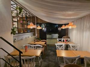 a restaurant with wooden tables and chairs and chandeliers at Freyja Hostal Boutique - Café Bistró in Bogotá
