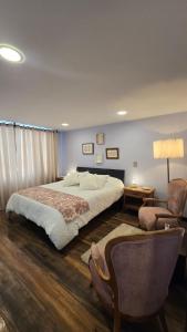 a bedroom with a large bed and a chair at Freyja Café Bistró - Hostal Boutique in Bogotá