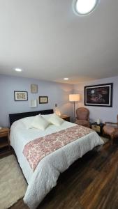 a bedroom with a large bed and a chair at Freyja Café Bistró - Hostal Boutique in Bogotá