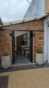 a brick wall with a patio with a table and chairs at Freyja Café Bistró - Hostal Boutique in Bogotá