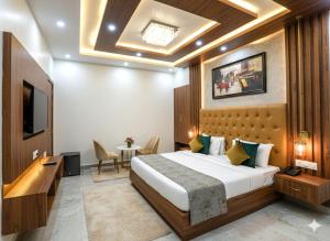 ニューデリーにあるWorldwide Suites Near IGI Airportのベッドとテレビがあるホテルの部屋