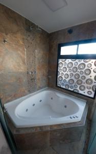 un bagno con ampia vasca e finestra di Cabañas La Morenita a Bialet Massé
