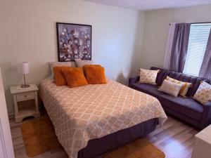 a bedroom with a bed and a blue couch at Habitacion Privada a 15 minutos de Walt Disney World in Kissimmee
