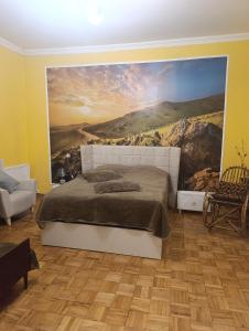 a bedroom with a large painting on the wall at Gamsakhurdia Street in Borjomi