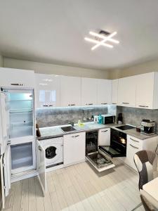 a kitchen with white cabinets and an open refrigerator at Central Home with Underground Parking in Varna City