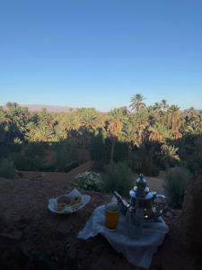 a table with a tea kettle and a plate of food at Auberge et Restaurant chez Alilouch in Nkob