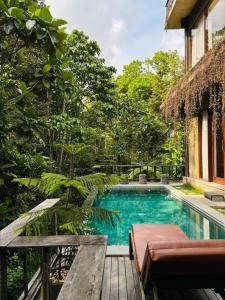 a swimming pool in the middle of a garden at ELForest ex Karang Dukuh Villa, Ubud in Payangan