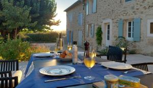 a blue table with plates and wine glasses on it at Mas des Mûriers in Clansayes +21 photos