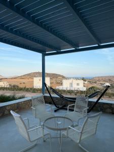 a group of chairs and a table on a patio at Filotimia in Schinoussa