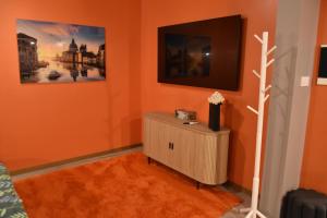 a living room with orange walls and a tv at Vinetas Apartments Nr4 Sunset in Cēsis