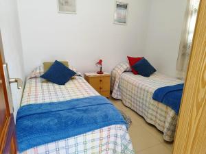 1 dormitorio con 2 camas y almohadas azules y rojas en Riegos de Lino, en Barlovento